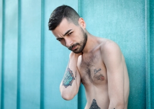 chico tatuado mirando a cámara