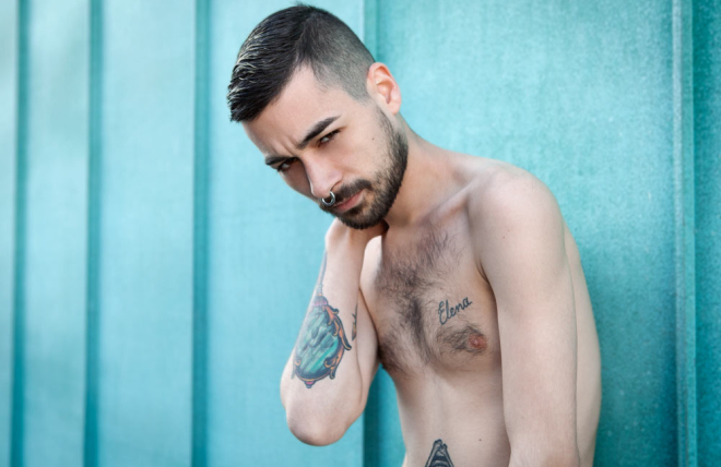 chico tatuado mirando a c&aacute;mara