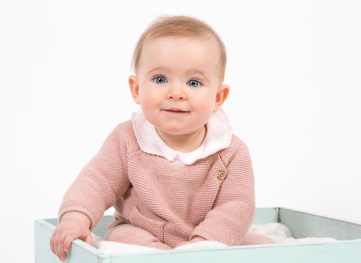 bebé sonriente con ojos azules y pelo rubio