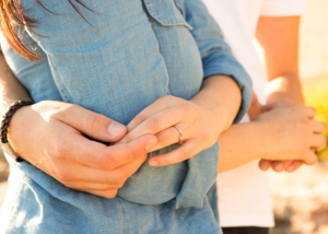 manos de pareja unidas con alianza